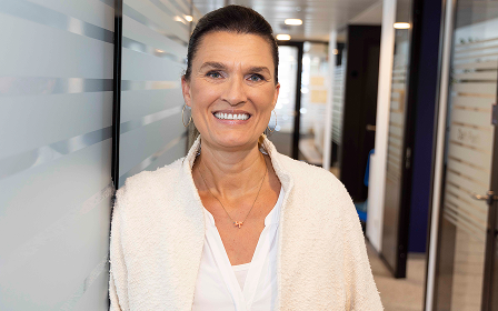 Porträt einer Geschäftsfrau Eine lächelnde Frau im Business-Outfit in einem modernen Büroflur.